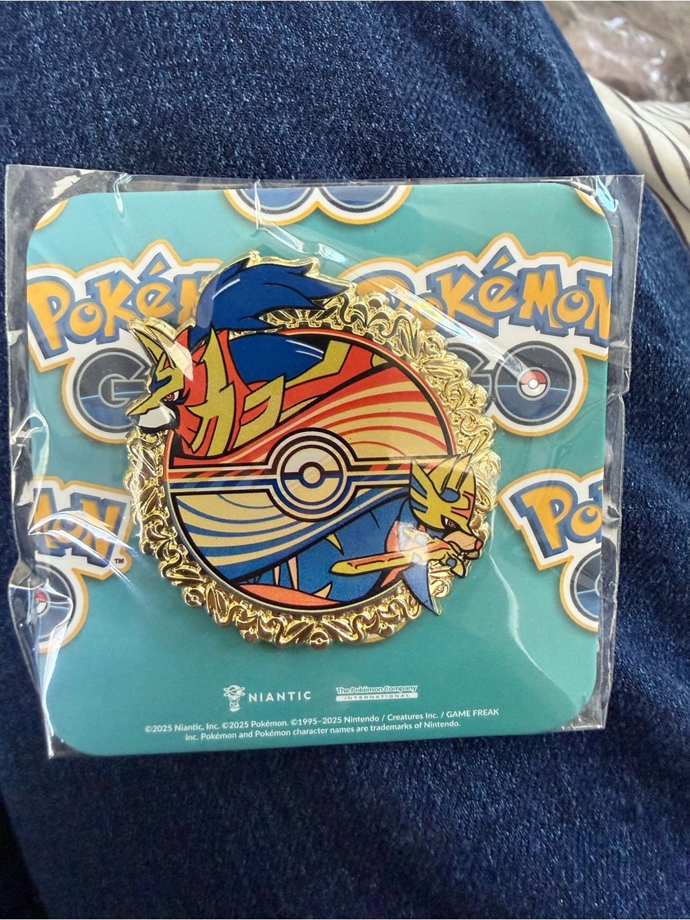 Pokemon gold-trimmed enamel collectors pin with blue, red, yellow accents